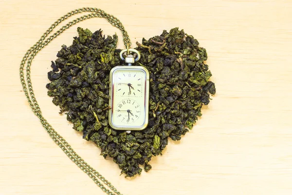 Hojas de té verde y reloj — Foto de Stock