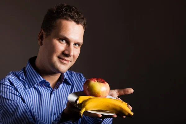 Happy young man holding fruits — Stock Photo, Image