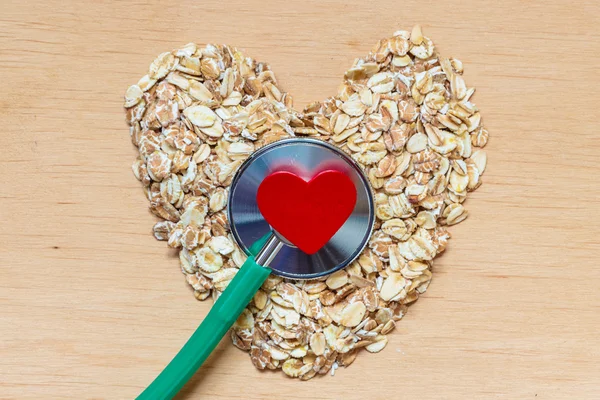 Flakes heart shaped and stethoscope. — Stock Photo, Image