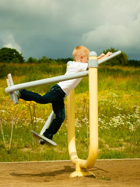 Junge spielen auf Stretchgeräten — Stockfoto