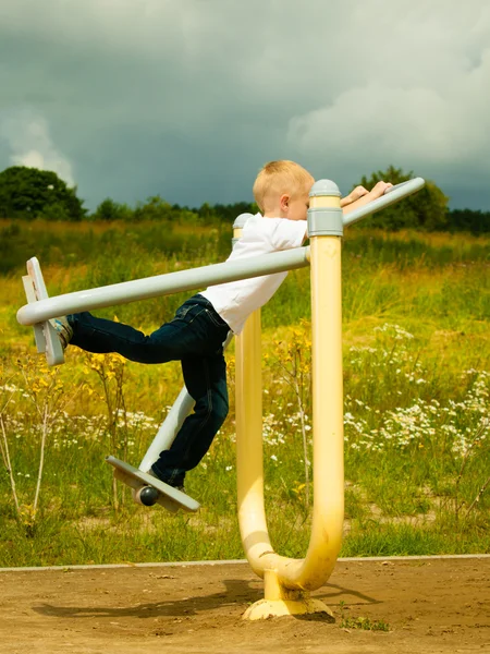 Pojke spela på stretching utrustning — Stockfoto