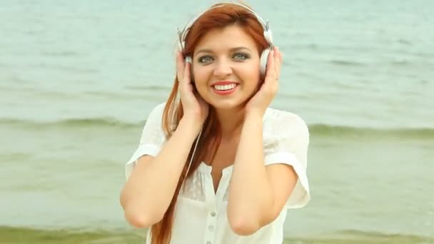 Kobieta na plaży słuchając nieskonczoność — Wideo stockowe