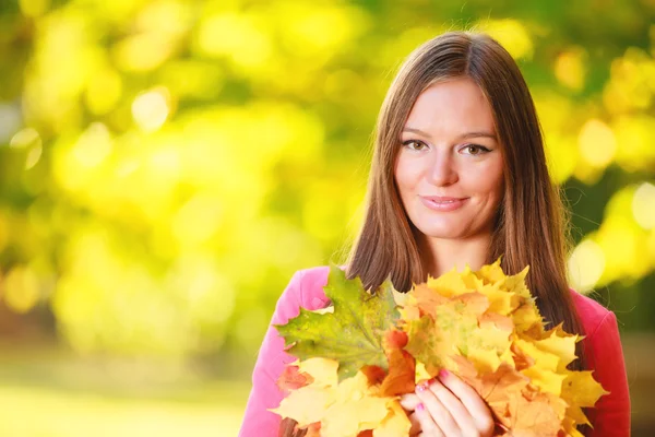 Frau mit herbstlichen Blättern — Stockfoto