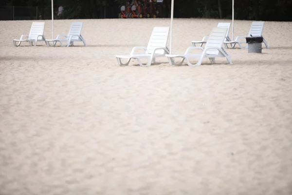 Vit pool stolar på sandstrand — Stockfoto