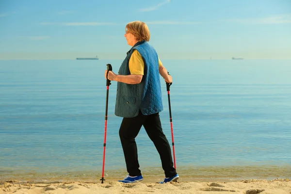 Seniorin spaziert am Strand — Stockfoto