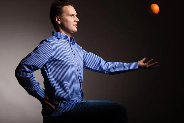 Man throwing orange — Stock Photo, Image