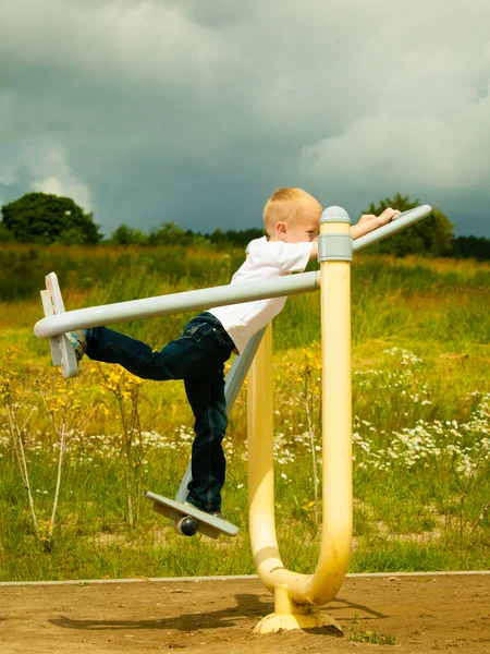 Junge spielen auf Stretchgeräten — Stockfoto