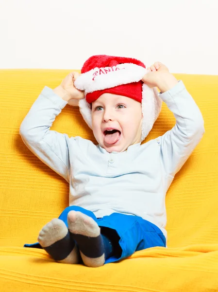 Niño en sombrero de santa en el sofá — Foto de Stock