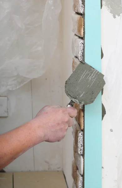 Byggnadsarbetare installerar kakel på vägg — Stockfoto
