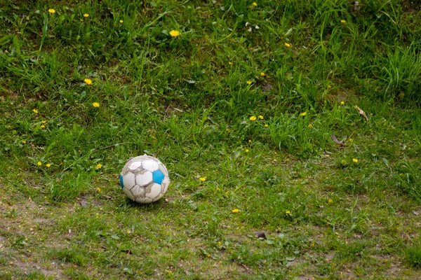 Old soccer ball on grass — Stock Photo, Image