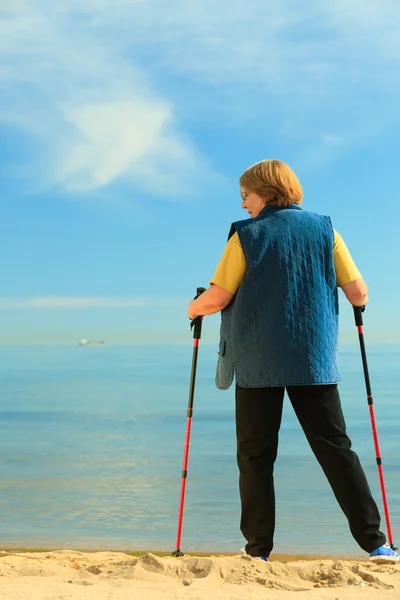 Seniorin spaziert am Strand — Stockfoto