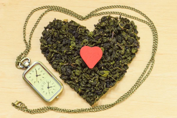 Hojas de té en forma de corazón y reloj — Foto de Stock