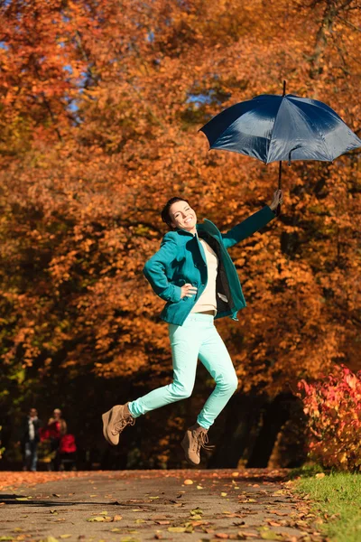 Meisje springen met paraplu in park — Stockfoto