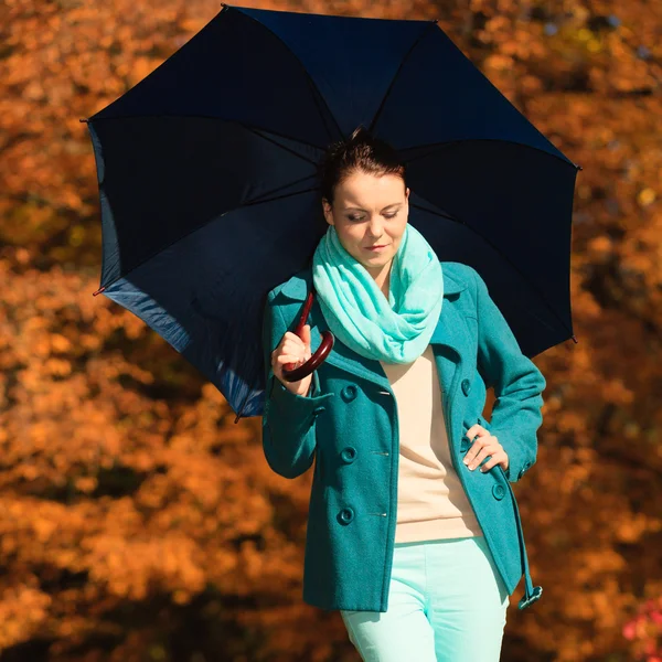 Frau läuft mit blauem Regenschirm — Stockfoto