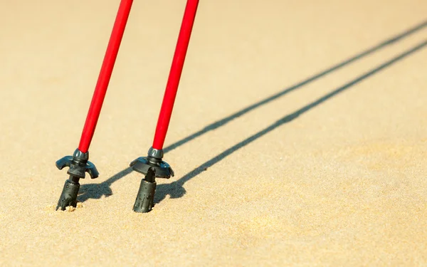 Red sticks on sandy beach — Stock Photo, Image