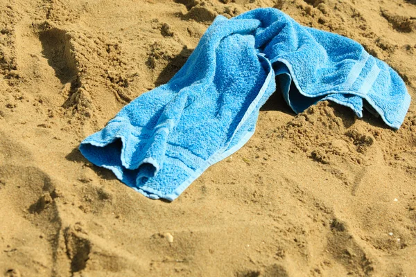 Blue towel on sandy beach — Stock Photo, Image