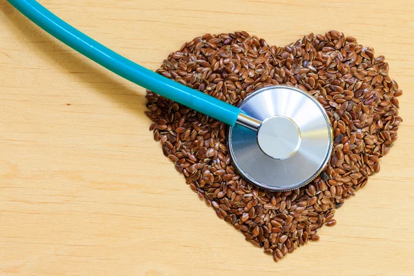 Semillas de lino en forma de corazón y estetoscopio — Foto de Stock