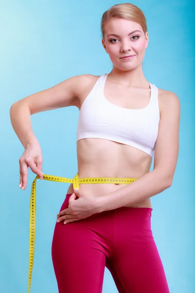 Mujer fitness midiendo su cintura —  Fotos de Stock