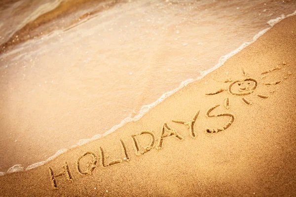 Word vakantie in sand geschreven — Stockfoto