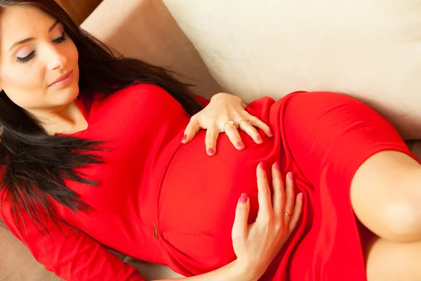 Femme enceinte relaxant sur canapé — Photo