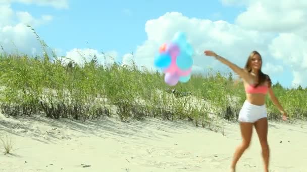 Menina com balões coloridos na praia — Vídeo de Stock