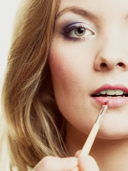Frau trägt Lippenstift mit Pinsel auf — Stockfoto