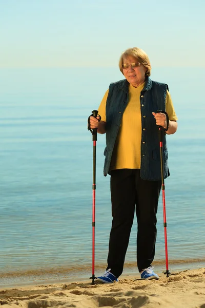 Seniorin spaziert am Strand — Stockfoto