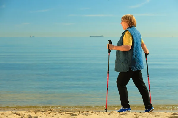 Mujer mayor caminando en la playa —  Fotos de Stock