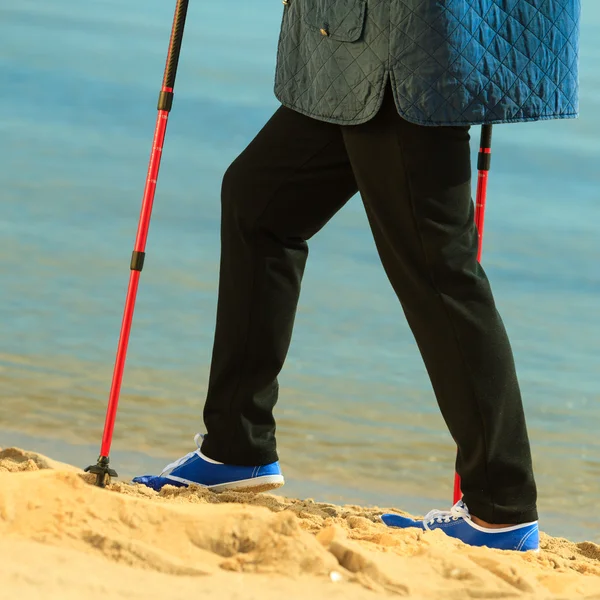 Seniorin spaziert am Strand — Stockfoto