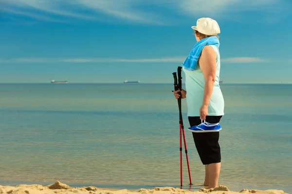 Kobieta senior spaceru na plaży — Zdjęcie stockowe
