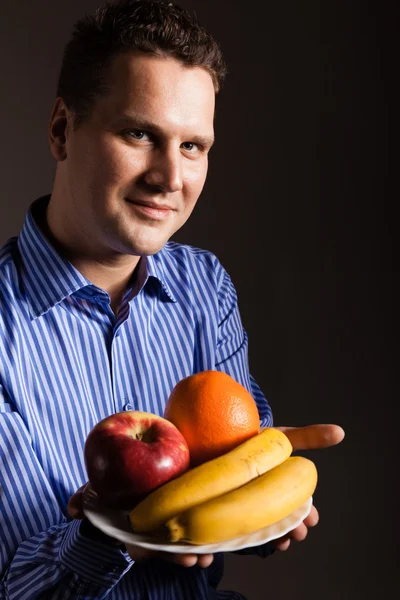 Happy young man holding fruits — Stock Photo, Image