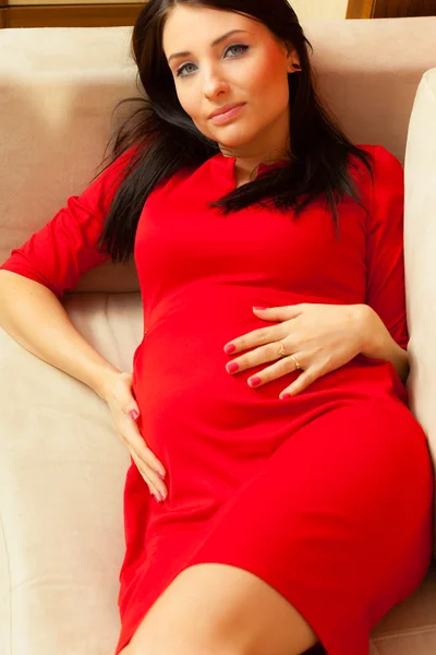 Femme enceinte relaxant sur canapé — Photo