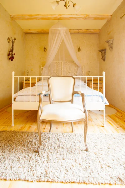 Canopy bed and retro chair Royalty Free Stock Photos