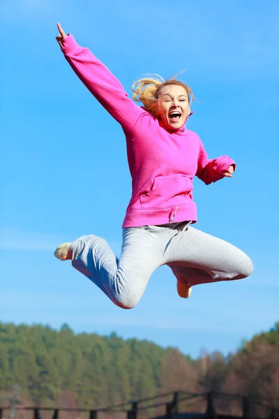 Fröhliche Frau im Trainingsanzug springt — Stockfoto