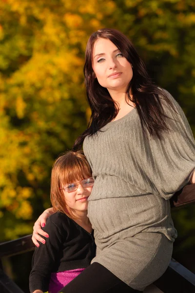 Mujer embarazada con hija en el parque —  Fotos de Stock