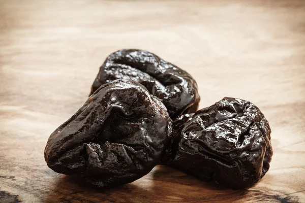 Dried plums on wooden table — Stock Photo, Image