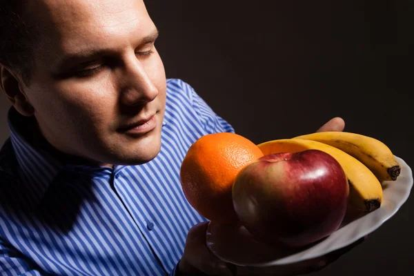 Feliz joven oliendo frutas — Foto de Stock