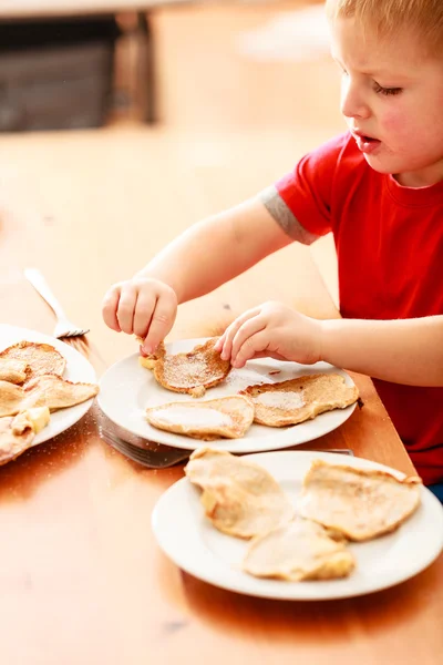 Kleine jongen eten apple pannenkoeken — Stockfoto