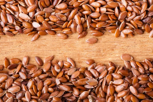 Flax seeds on wooden table — Stok fotoğraf