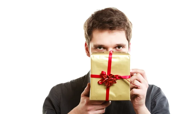 Holiday. Man giving golden gift box with ribbon — Stock Photo, Image