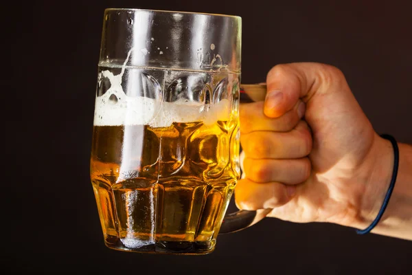 Male hand holding mug of beer — Stock Photo, Image