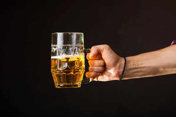 Male hand holding mug of beer — Stock Photo, Image