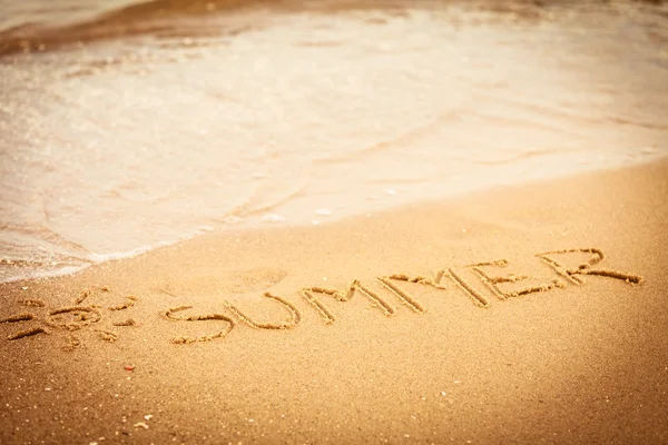 Woord zomer geschreven op zand — Stockfoto