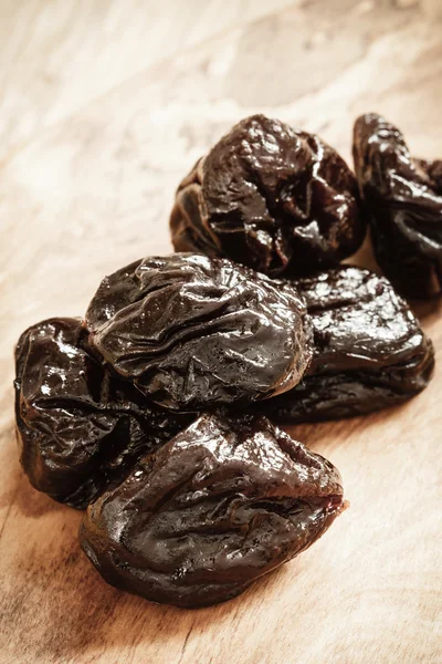 Dried plums on wooden table — Stock Photo, Image