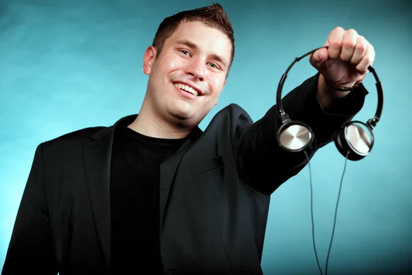 Smiling man offering headphones — Stock Photo, Image