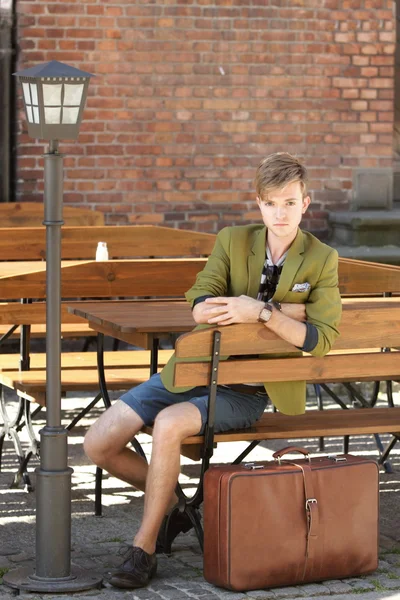 Man traveler with suitcase on bench — Stock Photo, Image