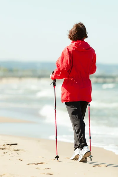 Nordic walking. Woman hiking on the beach. — Stock Photo, Image