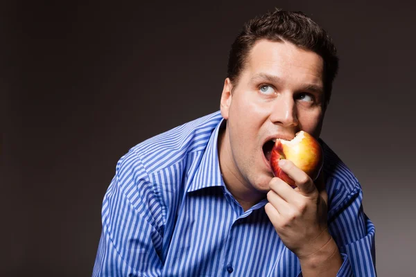 Homem feliz mordendo maçã — Fotografia de Stock