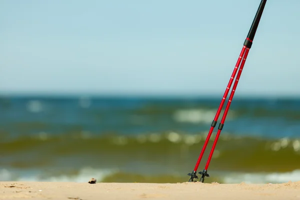 Red sticks on the sandy beach — Stock Photo, Image