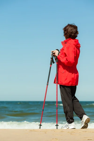 Σκανδιναβικό περπάτημα. Γυναίκα πεζοπορία στην παραλία. — Φωτογραφία Αρχείου